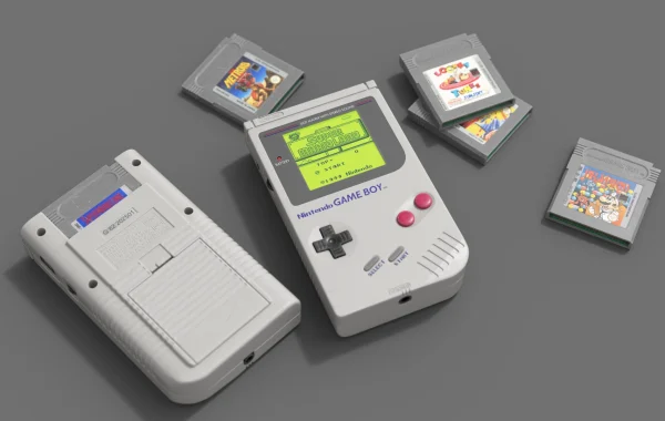 3D render of a Game Boy displaying the Super Mario Land start screen, a second console lying face down, and four cartridges