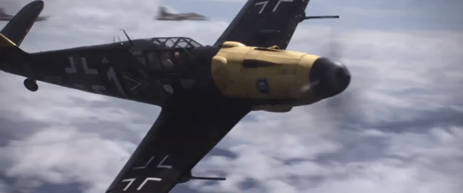 Close aerial view of a German Messerschmitt fighter with yellow engine cowling and black cross markings above clouds