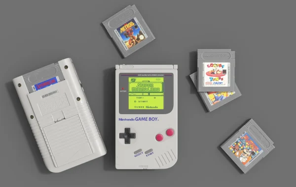Top-down 3D render of a Nintendo Game Boy showing the Super Mario Land title screen, with a second console and four cartridges